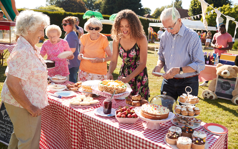 People at a cake stall at a school fete.